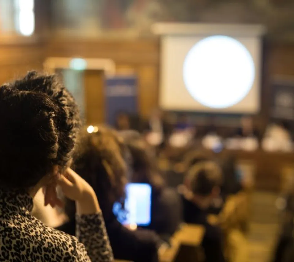 Étudiante prise de dos pendant qu'elle assiste à une conférence sur la notion de consentement au sein de l'amphithéâtre Turgot