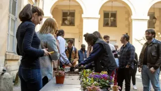 Personnels de l'université assistant à un atelier jardinage organisé dans la cour d'honneur du centre Panthéon