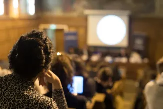 Étudiante prise de dos pendant qu'elle assiste à une conférence sur la notion de consentement au sein de l'amphithéâtre Turgot